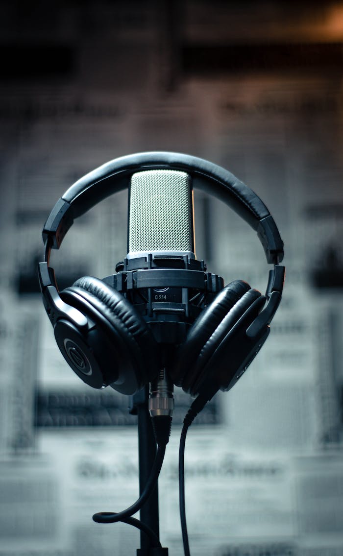 Microphone with headphones in a studio environment, perfect for sound recording and podcasting.